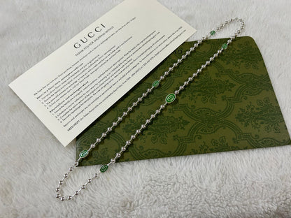 Collier vert à G entrelacés Double G