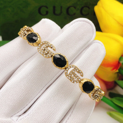 Bracelet manchette ouvert avec cristaux noirs et fleurs Double G 18 carats